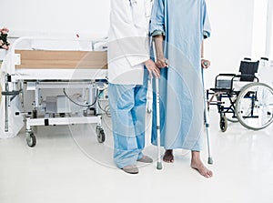 Doctor helping patient in crutches at the hospital