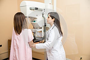 Doctor helping patient get a mammogram photo