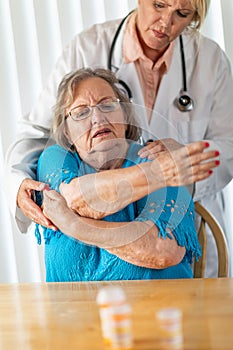 Doctor Helping Senior Adult Woman With Arm Exercises