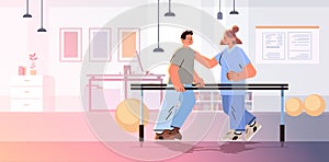 doctor helps patient after injury or medical operation during physio therapy man having physical rehabilitation in