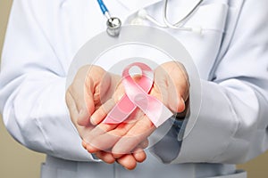 Doctor hold pink awareness ribbon, close up