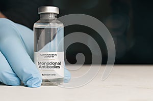 Doctor hold a vial of monoclonal antibodies, a new treatment for coronavirus Covid-19, on a white table