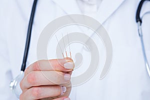 Doctor holding acupuncture needles