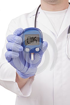 Doctor holding blood sugar meter. Ok sign