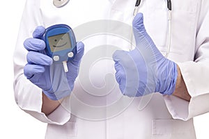 Doctor holding blood sugar meter. Showing OK sign