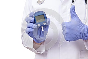 Doctor holding blood sugar meter. Showing OK sign