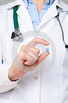 Doctor holding a blue a pill