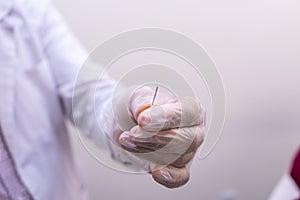 Doctor holding blunt needle prick, used before a hyaluronic acid HA based dermal filler treatment to allow gel injection to ente photo
