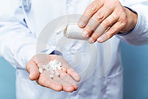 Doctor holding bottle of pills on white background. The concept of medicine, pharmacology, healthcare