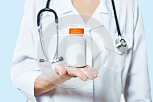 Doctor holding bottle of pills on white background. The concept of medicine, pharmacology, healthcare