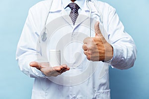 Doctor holding bottle of pills on white background. The concept of medicine, pharmacology, healthcare