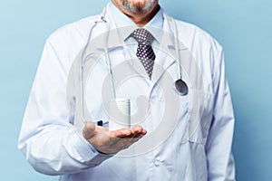 Doctor holding bottle of pills on white background. The concept of medicine, pharmacology, healthcare