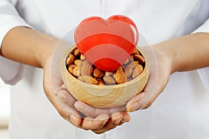 Doctor holding a bowl of almonds and heart shape - Health concept