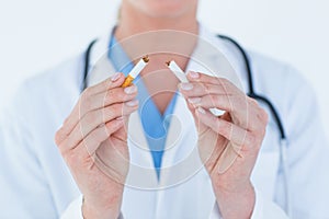 Doctor holding broken cigarette