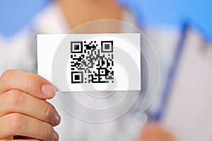 Doctor holding business card with QR code