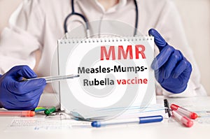 Doctor holding a card with diagnosis words MMR - Measles-Mumps-Rubella vaccine research. Healthcare medical concept. photo