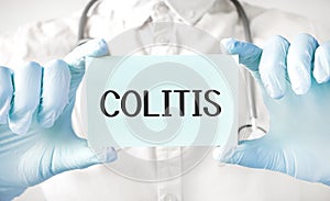 Doctor holding card in hands and pointing the word COLITIS