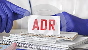 Doctor holding a card with text ADR, medical concept