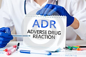 Doctor holding a card with text ADR, medical concept photo