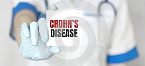 Doctor holding a card with text Crohn disease, medical concept