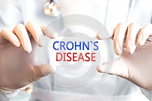 Doctor holding a card with text CROHNS DISEASE photo