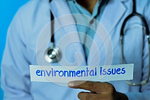 Doctor holding a card with text environmental issues. Medical and healthcare concept