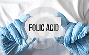 Doctor holding a card with text Folic Acid, medical concept