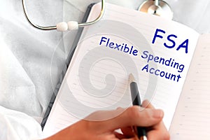 Doctor holding a card with text FSA Flexible Spending Account, medical concept