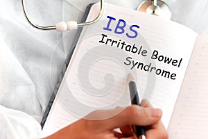 Doctor holding a card with text IBS, medical concept