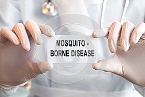 Doctor holding a card with text Mosquito - orne disease