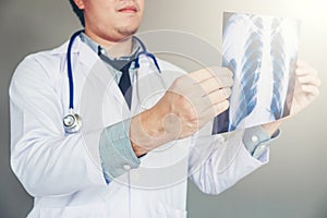 Doctor holding and checking chest x-ray film or roentgen image in ward hospital