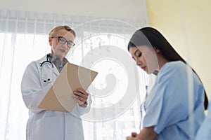 Doctor holding clipboard or application form for explaining diagnosis to her patient