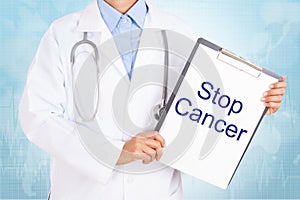 Doctor holding clipboard with stop cancer text on a sheet of paper.