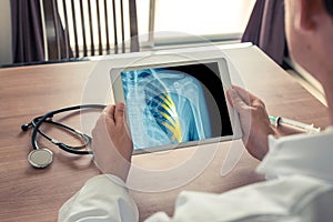 Doctor holding a digital tablet with x-ray of chest and pains on the ribs