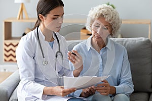 Doctor holding documents, consulting older woman about checkup result