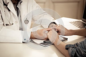 Doctor holding female patient hands with compassion and comfort for encouragement and empathy