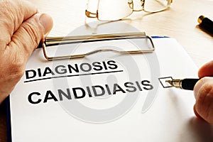 Doctor holding form with Candidiasis. photo
