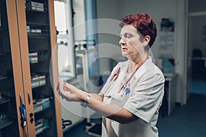 Doctor holding glass medical ampoule