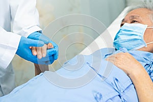 Doctor holding hand Asian senior or elderly old lady woman patient wearing a face mask in hospital