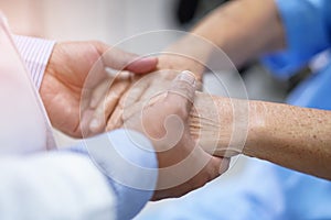 Doctor holding hands Asian senior or elderly old lady woman patient with love, care