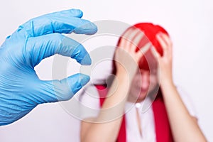 Doctor holding a headache pill that relieves stress and migraine, painkiller, antispasmodic