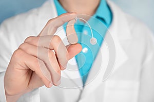 Doctor holding hearing aid, closeup