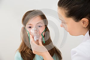 Doctor Holding Inhaler Mask For Girl Breathing