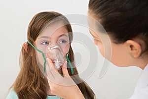 Doctor Holding Inhaler Mask For Girl Breathing