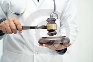 Doctor holding judge gavel, forensic medicine, medical law and crime justice concept