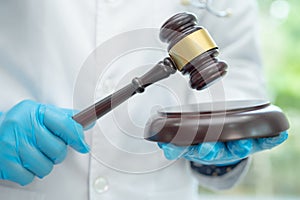 Doctor holding judge gavel, forensic medicine, medical law and crime justice concept