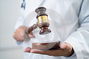 Doctor holding judge gavel, forensic medicine, medical law and crime justice concept