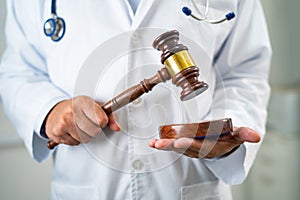 Doctor holding judge gavel, forensic medicine, medical law and crime justice concept