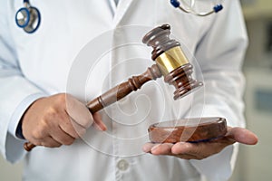 Doctor holding judge gavel, forensic medicine, medical law and crime justice concept