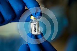 Doctor holding and looking covid-19 vaccine in hospital